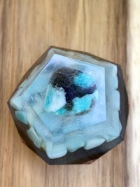 an octagon shaped piece of glass with a blue stone in it