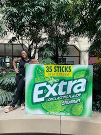 a woman standing next to a sign for extra mints