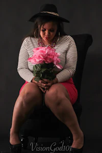 a woman sitting on a chair holding a bouquet of roses