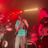 a group of young men playing guitars on stage