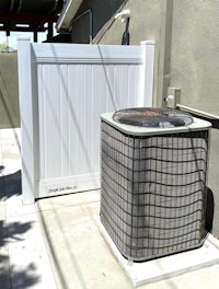 a white air conditioner sits outside of a building