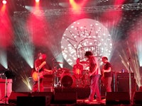 a group of people on stage with red lights behind them
