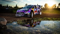 a purple rally car driving through a puddle of water