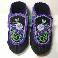 a pair of black and purple moccasins with flowers on them