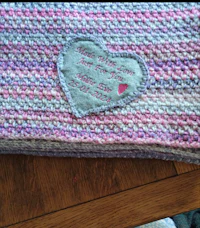 a crocheted blanket with a heart on it