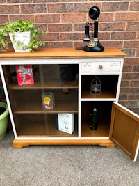 a wooden bookcase with a glass door