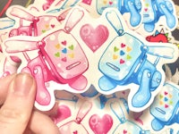 a person holding up a bunch of stickers with hearts on them