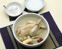 a bowl of soup with a chicken in it