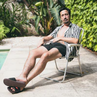 a man sitting in a chair next to a pool