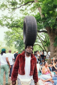 a man carrying a tire on his head