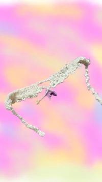 a white crocheted bird flying in the sky