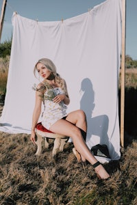 a woman sitting on a chair in a field