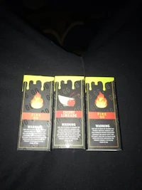 three boxes of e-liquid sitting on a bed