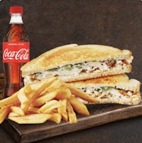 a grilled chicken sandwich with fries and coca cola