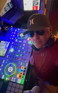 a man in sunglasses standing in front of a dj booth
