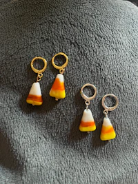 three candy corn charms on a blanket