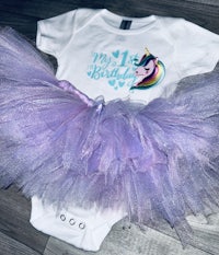 a unicorn tutu and bodysuit on the floor