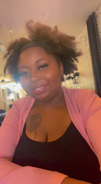 a woman in a pink top with a tattoo on her arm