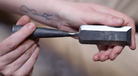 a person is holding a small piece of metal