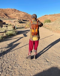 a person walking down a dirt road with a backpack
