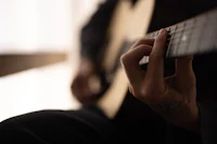 a close up of a person playing an acoustic guitar
