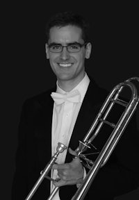 a man holding a trombone in front of a black background