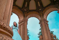 a woman in a blue dress standing on a staircase
