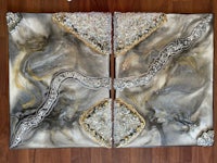two silver and gold paintings on a wooden floor