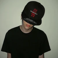 a young man wearing a black hat