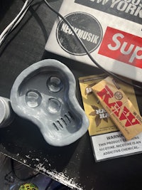 a tray on a table next to a book and a cigarette