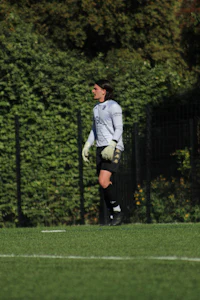 a soccer player is catching a ball on a field