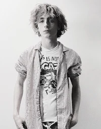 a black and white photo of a young man with curly hair
