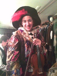 a woman dressed in a renaissance costume holding a violin
