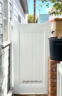 a white wooden gate in front of a house