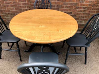 a wooden dining table with four black chairs