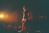 a woman standing on a platform in front of a crowd