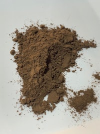 a pile of brown powder on a white plate