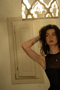 a woman in a black dress posing in front of a mirror