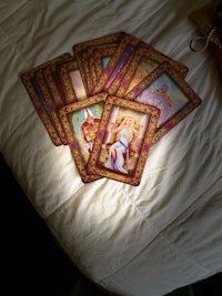 tarot cards on a bed with a light shining on them