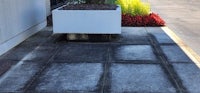 a concrete sidewalk with a planter in front of a building