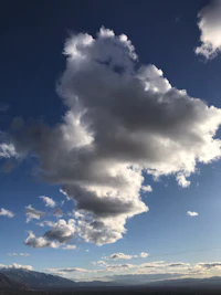 a cloudy sky with mountains in the background