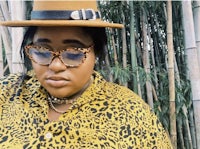 a woman wearing a hat and leopard print shirt