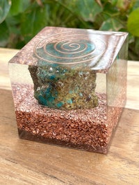 a turquoise stone is sitting on top of a wooden block