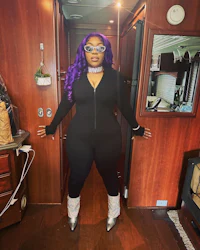 a woman in a black jumpsuit standing in a rv