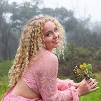 a girl in a pink dress holding a bouquet of flowers
