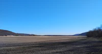 a plowed field with mountains in the background