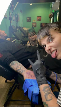 a woman is getting a tattoo at a tattoo shop