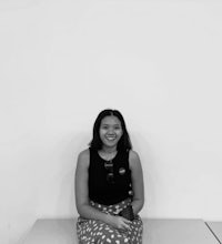 a black and white photo of a woman sitting on a bench