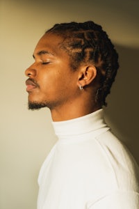 a young man with dreadlocks looking at the camera