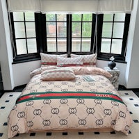 a bed with a gucci print on it